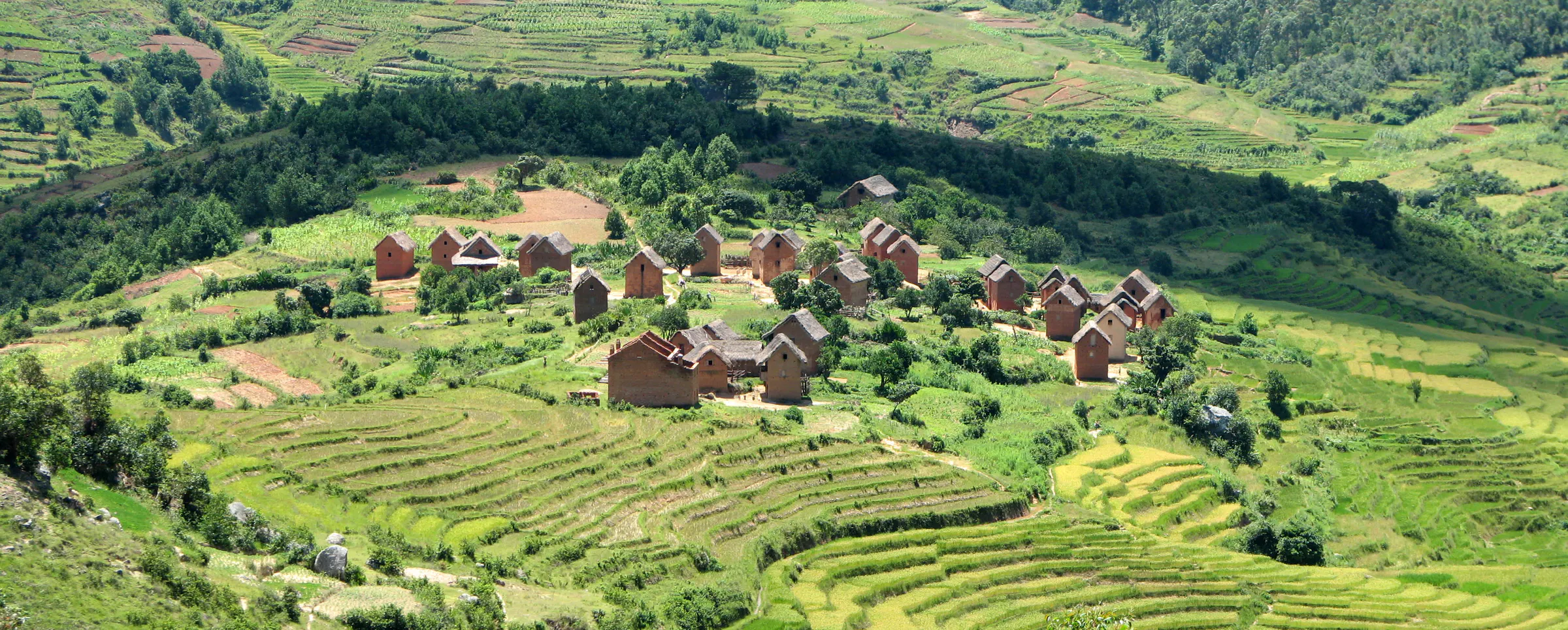 Panorama d'un village en briques entouré de rizières en terrasses sur les Hautes Terres